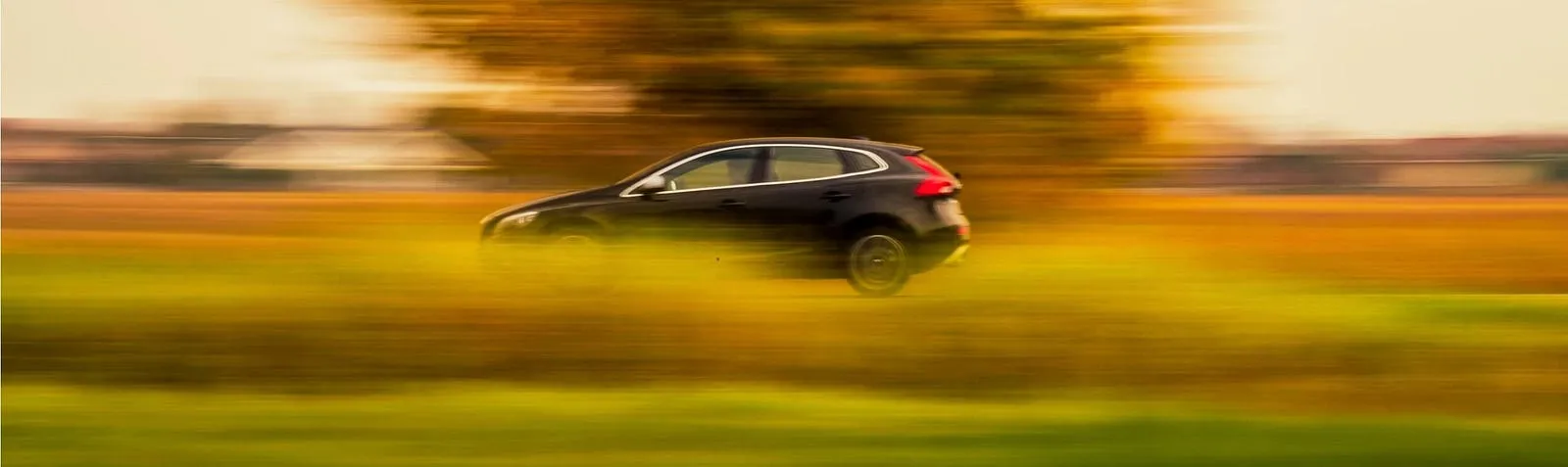 Carro em movimento numa estrada, com o fundo desfocado pela velocidade